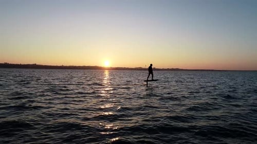E Foil Sunset boating on the water. Paddleboard, stand-up surfing on electric foil. Aerial drone sho
