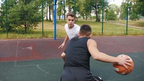 Sportsman in Black Uniform Playing Basketball on the Court Outdoors