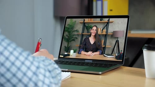 Woman on Video Call Waving from Home Office
