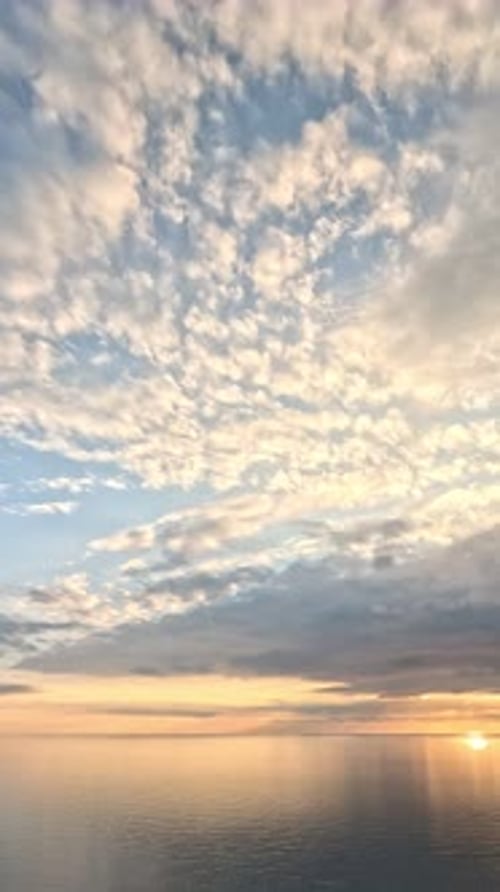 Timelapse : cumulus moelleux se déplaçant dans un ciel doré brillant au coucher du soleil au-dessus de la mer, nature aérienne abstraite