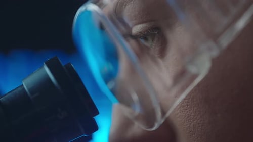 Close Up of Person Looking Through a Microscope