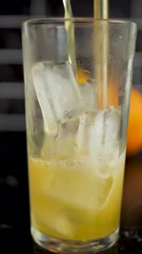 Refreshing Drink Poured over Ice into Glass