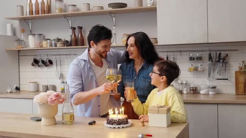 Family Celebrating Birthday With Cake and Toast in Kitchen