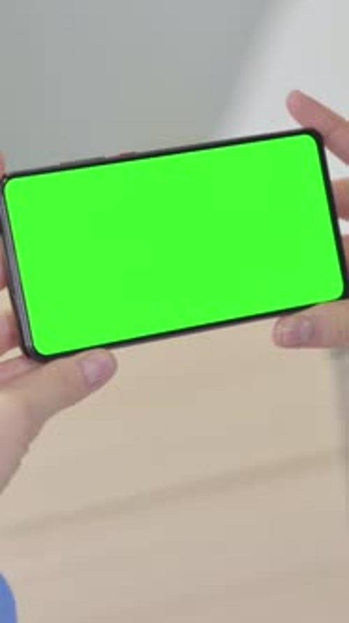 Woman Holding Horizontal Smartphone with Green Screen, Vertical Video