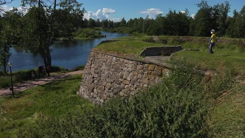 Des gens se baladent dans la forteresse muséale de Korela, près du lac, et sont émerveillés par sa enchanteresse, Ru