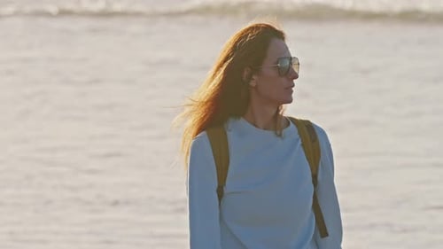 Portrait of a Girl in Glasses Closeup Against the Ocean at Sunset