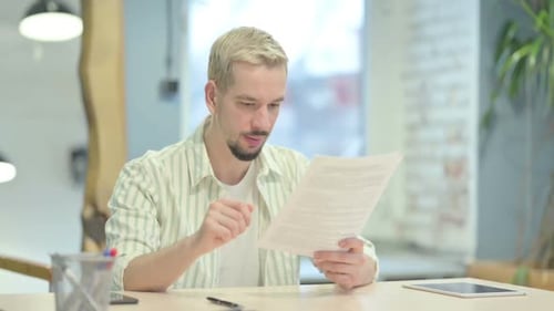 Man Celebrates Reading Good News in Office