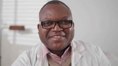 Smiling Man Wearing Glasses and a White Coat