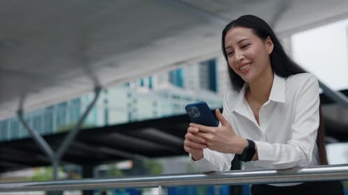 Young Business Woman Standing Outside Near Business District And Checking Out Funny Clips in Social