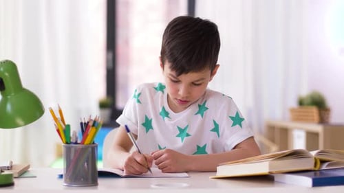 Konzept „Bildung, Kindheit und Menschen“ — Junge schreibt zu Hause auf Notizbuch, schön