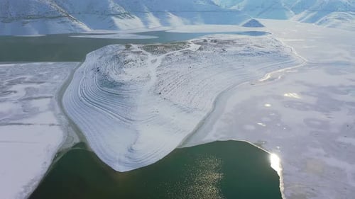 Frozen lake. Drone fly over lake in winter time. Snow on lake. Icy lake in white mountains.
