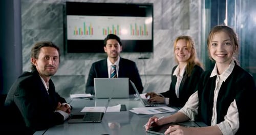 Team of professionals engaging in office meeting, businessman and female colleagues using laptops