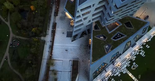 Drone shot of a abstract building Intressting architecture by a parc with people and a restaurant