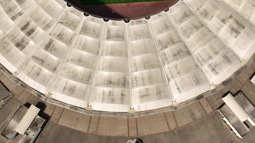 Aerial flyby over an empty football stadium with a pitch and tracks