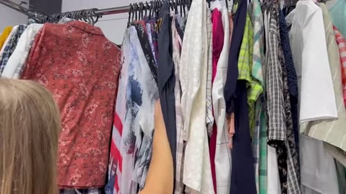 Woman Browsing Colorful Clothing Rack