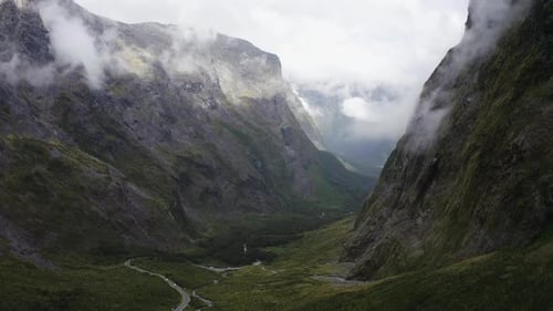 Estrada sinuosa passando por montanhas, neblina e nuvens em Milford Sound, Nova Zelândia, no sul I