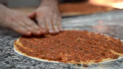 Chef of bakery making a Turkish pizza or lahmacun 4K