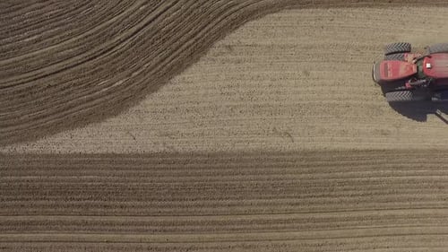 Big red combine working on the field cultivating and applying nitrogen ASP