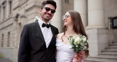 Smiling Wedding Couple Outside Elegant Building