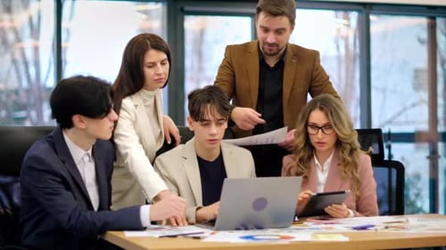 Business meeting in an office, workers discussing business affairs using gadgets and papers