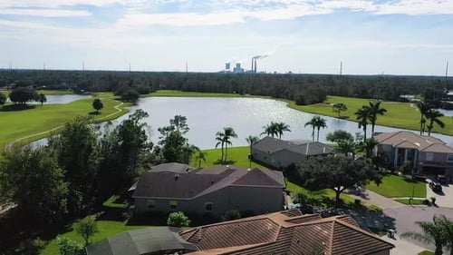 Aerial video of residential neighborhood in shadow of coal-burning power plant