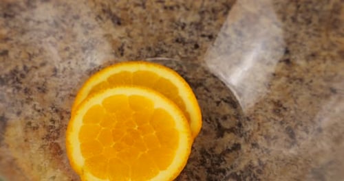 Fresh Orange Slices Added to Bowl