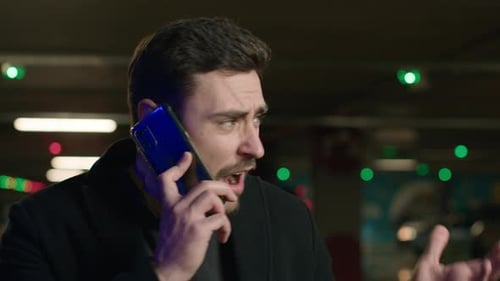 Adult Man Arguing on Cell Phone in Parking Garage