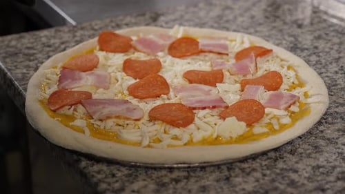 Primer plano del chef poniendo la salchicha en la masa de pizza Pizza de pepperoni