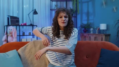 Woman Speaking to Camera on Living Room Couch