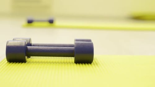 Dumbbells on Yellow Exercise Mat for Fitness