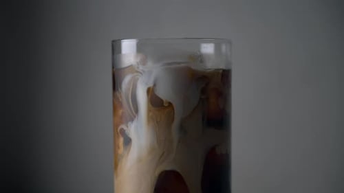 Creamy Milk Flowing into Glass of Cold Brew