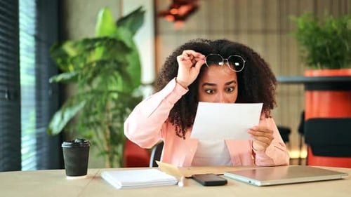 Excited Woman Reads Good News Letter and Celebrates Personal Success in Office