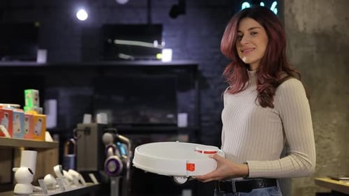 Smiling Woman Buying Wireless Vacuum Cleaner at Store