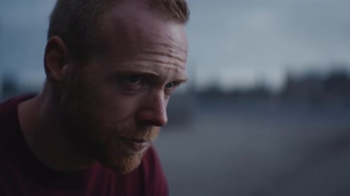 Bearded Man Staring Thoughtfully In Outdoor Setting