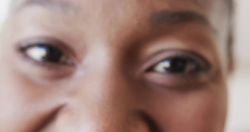Portrait close up of eyes of happy african american woman smiling, in slow motion, copy space