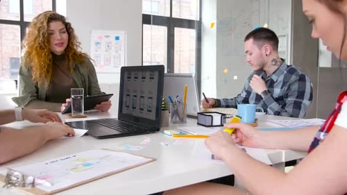 Colleagues Collaborating on Tech Project in an Office
