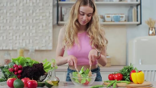 Woman Prepares Fresh Salad in Bright Kitchen