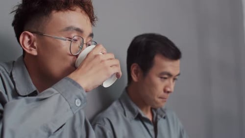 Construtores bebendo chá e falando sobre estratégia de renovação usando laptop