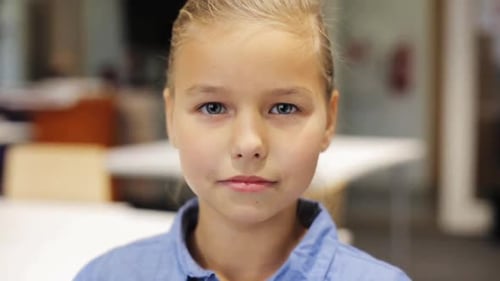 Happy smiling preteen girl face expressing joyful emotion at school classroom