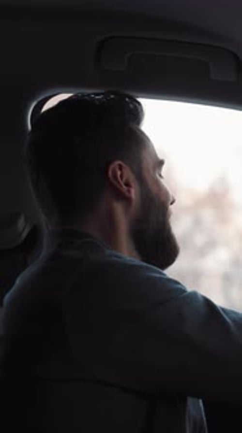 Smiling Man Driving a Car in the City