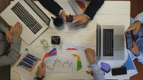 Top View to Male and Female Arms of Coworkers Plan a Future Project Sitting at Table Group of