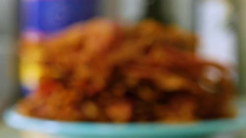 Pile of crispy bacon strips stacked on plate on counter, close up focus pull