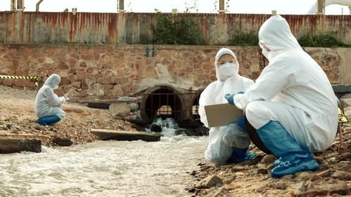 Scientists Sampling Stream Water Wearing Protective Suits