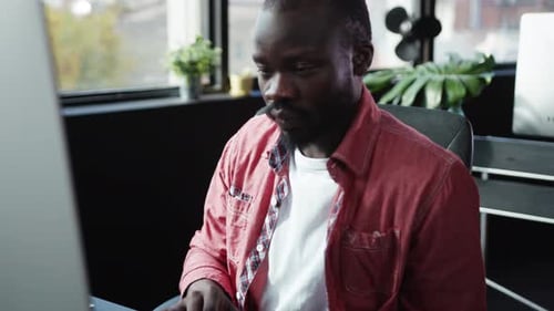 Young Adult Typing on Computer at Office Desk