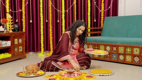 Mujer india haciendo rangoli en el festival de Diwali