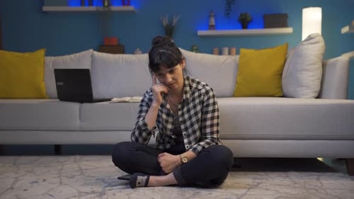 Woman Thinking, Sitting on the Floor in a Living Room