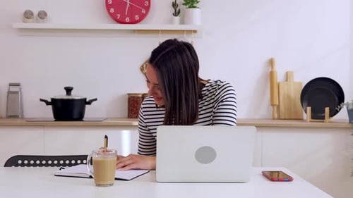 Woman Works on Laptop at Kitchen Table