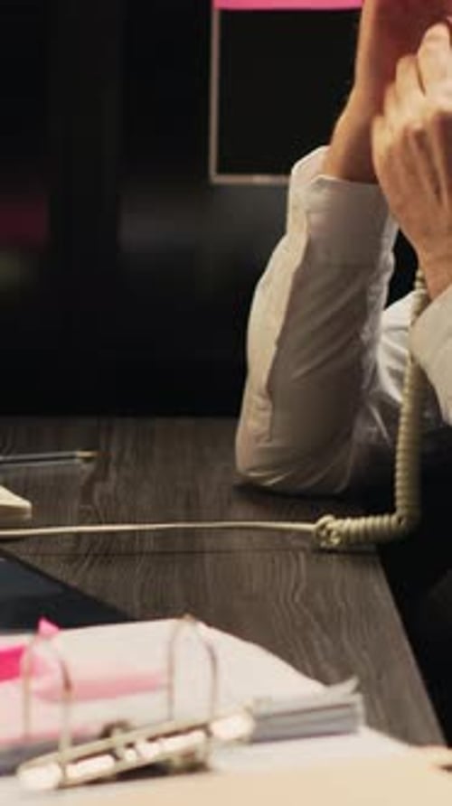 Man Typing on Computer and Talking on Phone