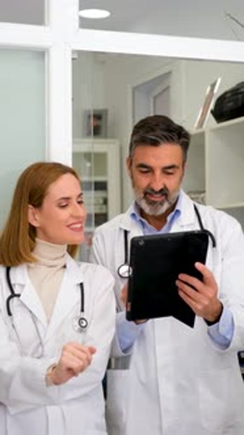 Doctors Reviewing Tablet in Bright Office Setting
