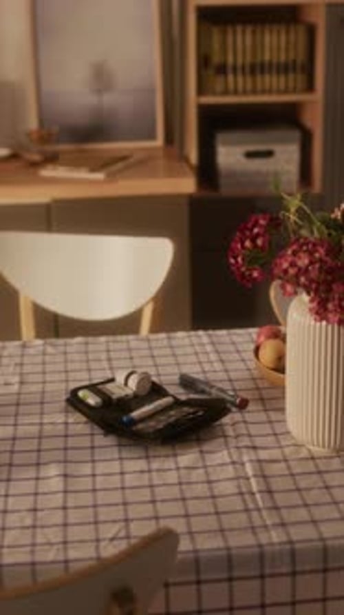 Table with Flower Vase, Pens, and Books